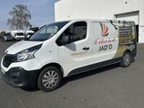 une camionnette blanche garée sur un parking près d'un immeuble
