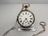 une petite montre de poche attachée à une chaîne