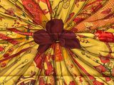 an image of a yellow and red square scarf with a red bow
