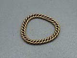 gros plan d'une bague en or sur une surface grise
