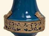 un vase bleu orné de motifs dorés sur fond blanc