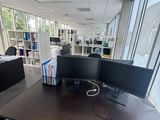 a desk with two monitors on it in an office