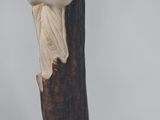 a statue of a man with a hat on top of a pole