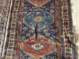 un tapis très ancien posé sur le sol de la pièce
