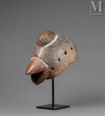 a wooden mask on a stand with a gray background