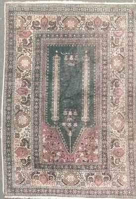 an antique rug with a green background and a pink border