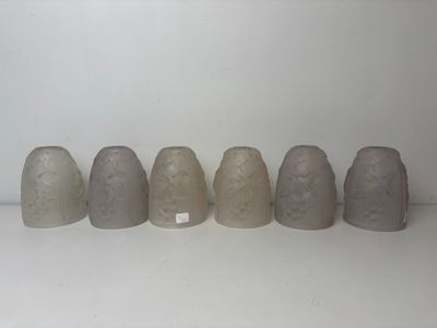several vases are lined up in a row on a white surface