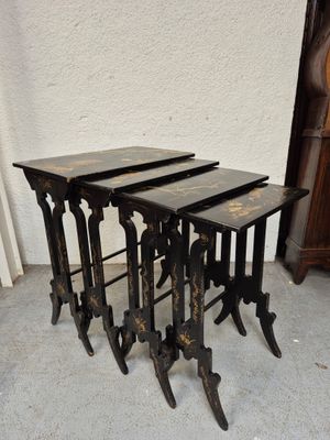 trois tables gigognes noires placées les unes à côté des autres sur un sol en béton