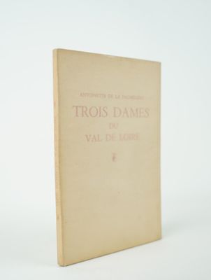un vieux livre posé sur une table à côté d'un mur blanc
