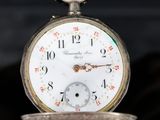 a close up of a pocket watch on a table
