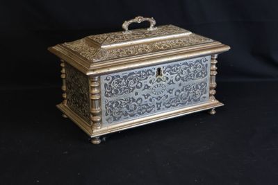 an ornate silver and gold box on a black background