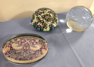 trois récipients en verre posés sur une table à côté d'une boule en verre