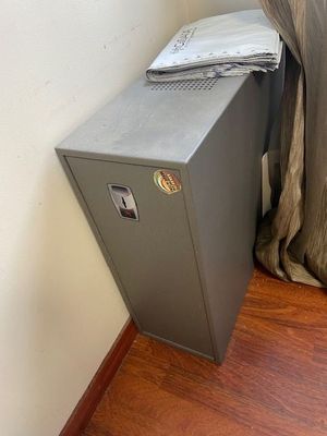 an image of a small metal cabinet in the corner of a room