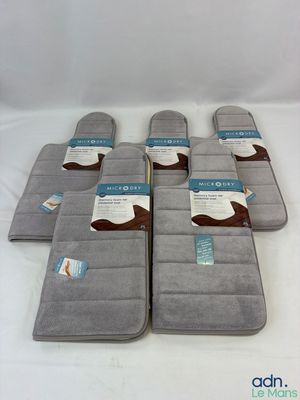 six gray and white bath mats with a cow design on them