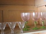 six wine glasses sitting on a shelf in a cabinet
