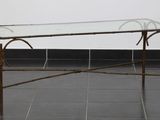 une table en verre avec un cadre en métal et un plateau en verre