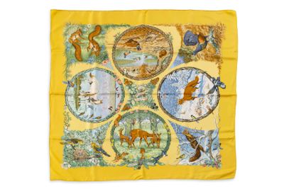 L'écharpe jaune est ornée d'un motif représentant des animaux et des oiseaux.