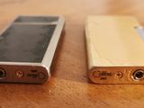 two cell phones sitting side by side on a wooden table