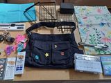une table sur laquelle se trouvent de nombreux objets, notamment un sac à main et d'autres objets