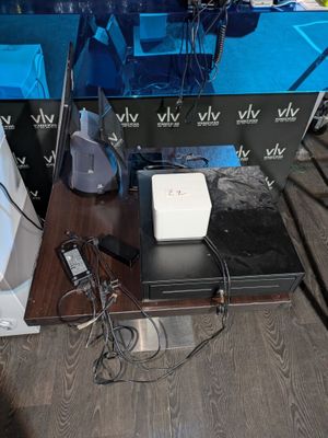 une table sur laquelle se trouvent un ordinateur portable, une télévision et d'autres appareils électroniques