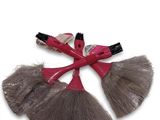 une brosse à cheveux rouge et grise ornée d'un nœud sur le dessus