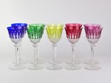 six different colored wine glasses in a row on a white surface