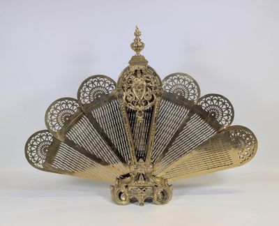 un ventilateur en laiton orné d'un motif décoratif sur le dessus