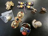 a lot of jewelry on a table with a bag