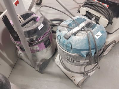 several vacuums are lined up on a table in a room
