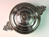 a silver plate with a handle on a white table