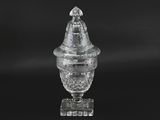 a close up of a glass vase with a lid on a black background
