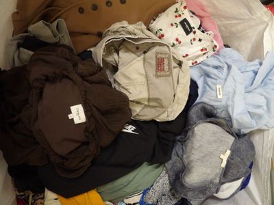 a pile of clothes that is sitting on a bed