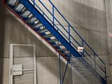 a blue stair going up to the top of a building