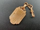 an image of a gold plated keychain on a black surface