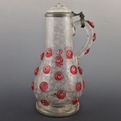 une image représentant un pichet en verre orné de roses rouges