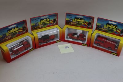 trois jouets emballés représentant un camion de pompiers rouge et un camion de pompiers rouge