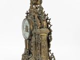 a clock that is sitting on a stand on a white surface