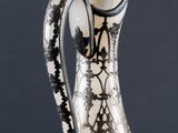 a silver vase with a black and white design on it