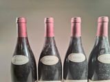 four bottles of wine are lined up on a table