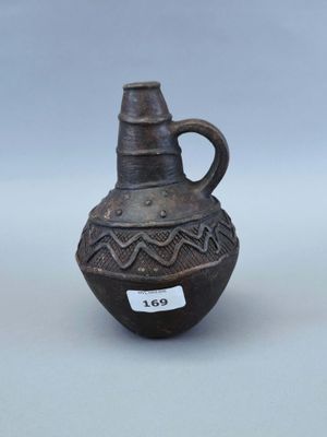 un petit vase marron muni d'une étiquette