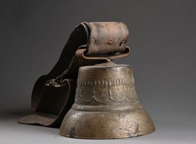 une cloche en métal à laquelle est attachée une pochette en cuir