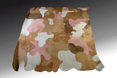 un tapis en cuir de vachette marron et rose posé sur un sol gris