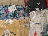 a lot of baby clothes that are on the couch