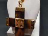 a cross made of gold and tortoises on a white display