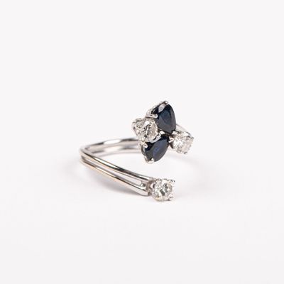 un gros plan d'une bague sertie d'un saphir bleu et de diamants blancs