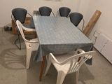une table et des chaises dans une pièce avec une fenêtre bleue