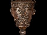 a bronze vase on a pedestal on a black background