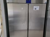 two stainless steel refrigerators in a room with tile flooring
