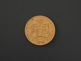 a close up of a gold coin on a black surface