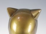 a gold piggy bank sitting on a white surface